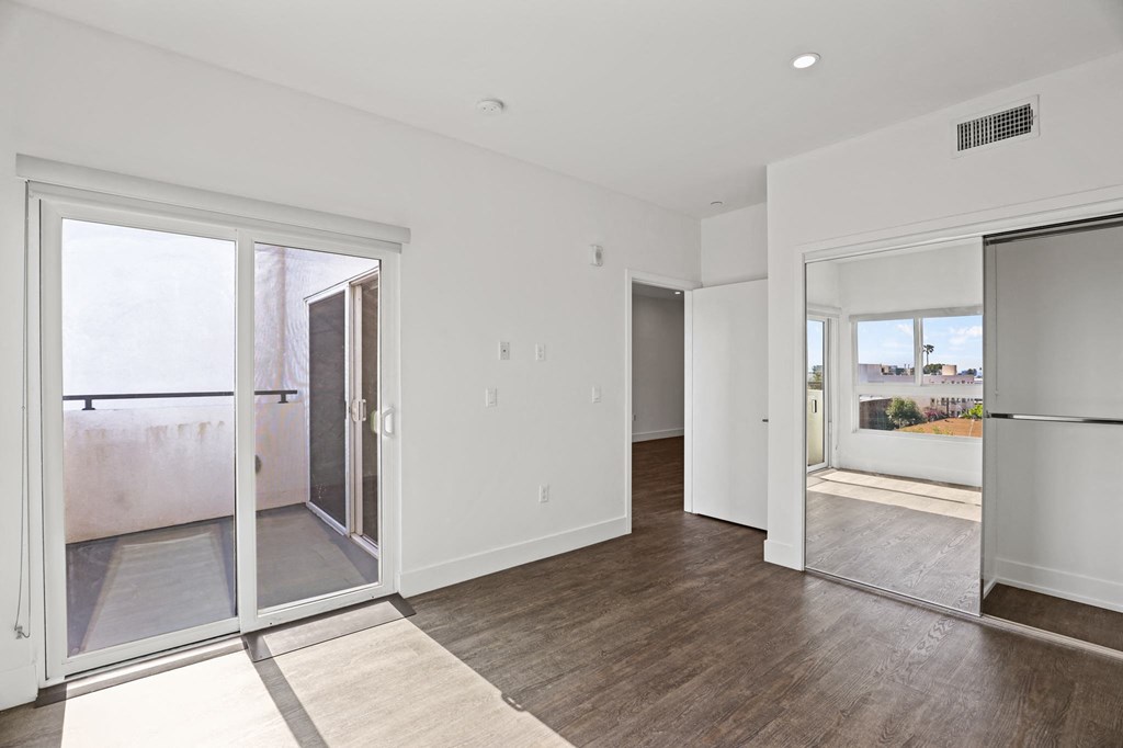 Bedroom with Mirrored Closet, Vinyl Flooring, and Patio