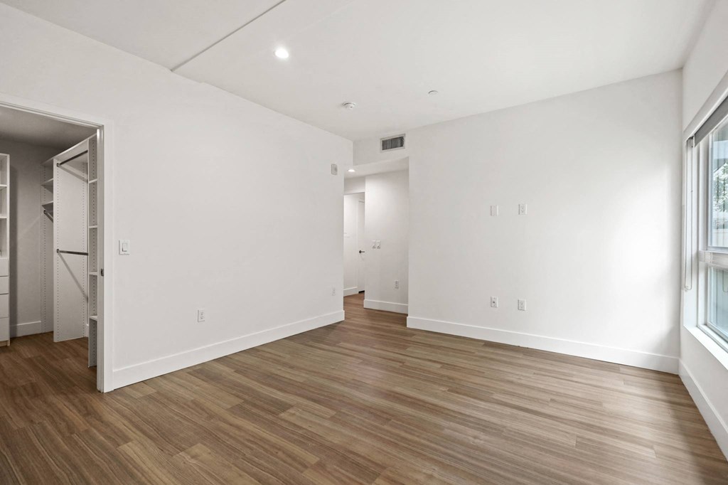 Bedroom with Walk-In Closet, Vinyl Flooring, Recessed Lighting, and Large Window