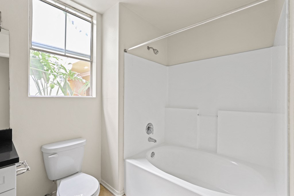 Bathroom with Window, Bathtub, and Cabinet Storage