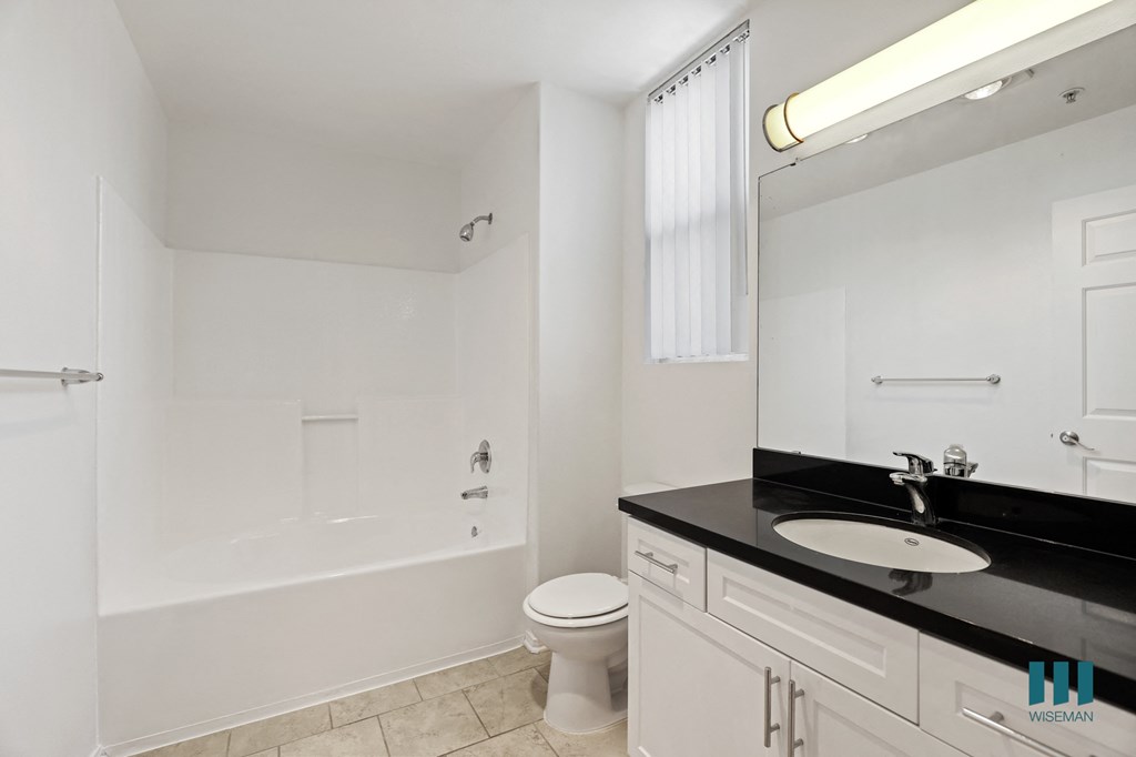 Bathroom with Full-Size Bathtub, Vanity Cabinet Storage, and Window