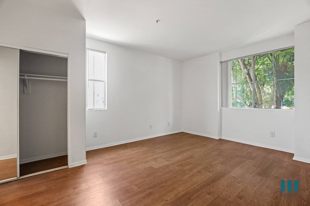 Bedroom with Large-Size Windows, Mirrored Closet, and Vinyl Flooring