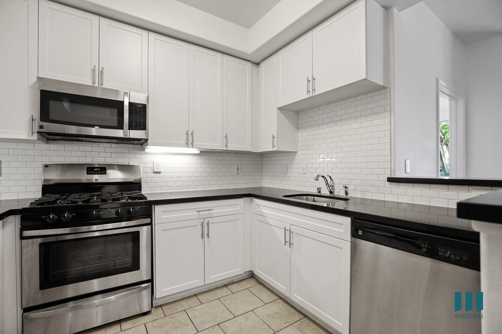 Kitchen with Stainless-Steel Stove, Microwave Oven, Dishwasher and Countertop Bar
