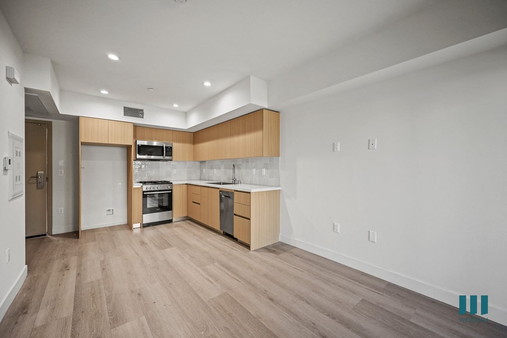 A kitchen with wooden floors and white walls.