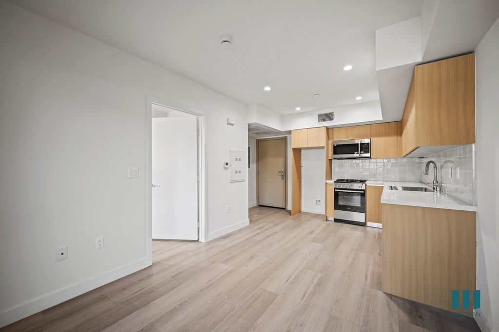 A kitchen with white appliances and wooden cabinets.