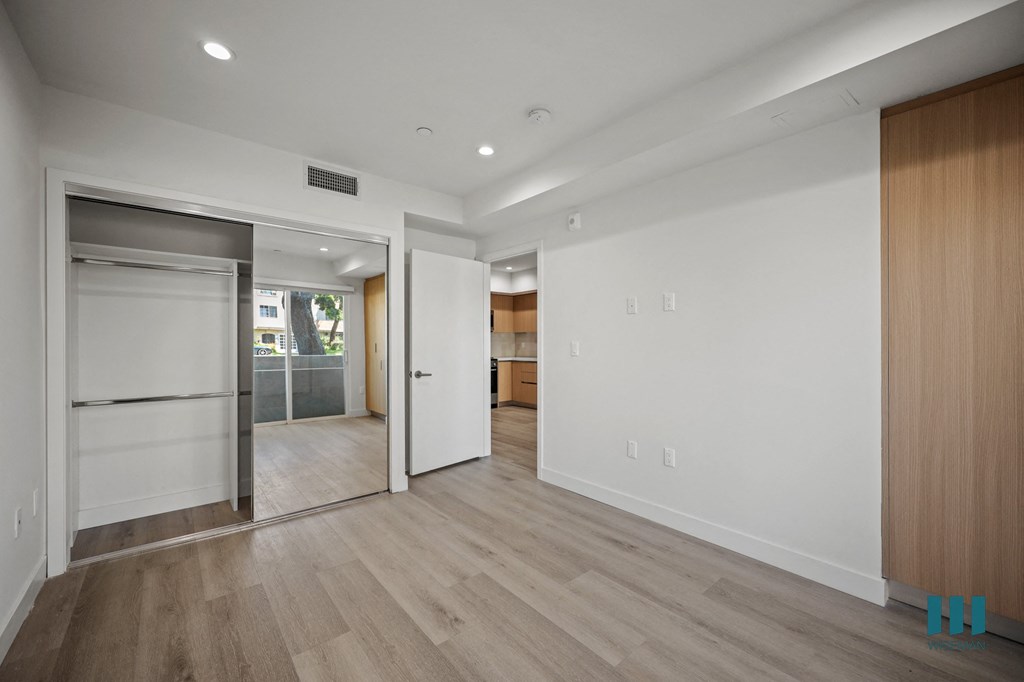 A room with a white wall and a wooden floor.