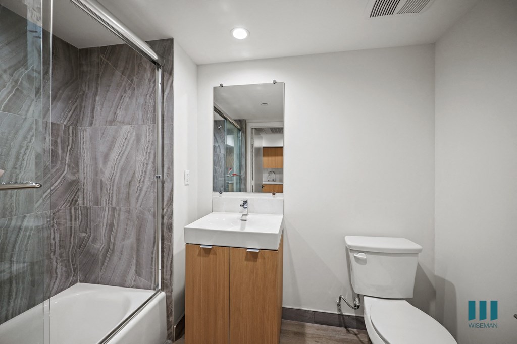 A bathroom with a toilet, sink, and shower.