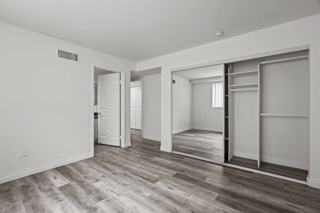 Bedroom with Mirrored Closet and Vinyl Flooring
