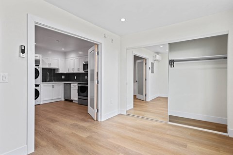 Bedroom with Double-Doors Leading to Open-Concept Kitchen