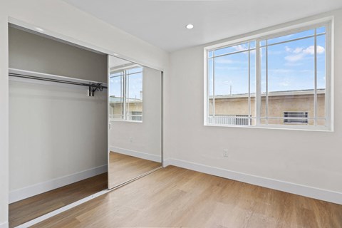 Bedroom with Double Windows, Large-Size Mirrored Closet, Vinyl Flooring, and Recessed Lighting