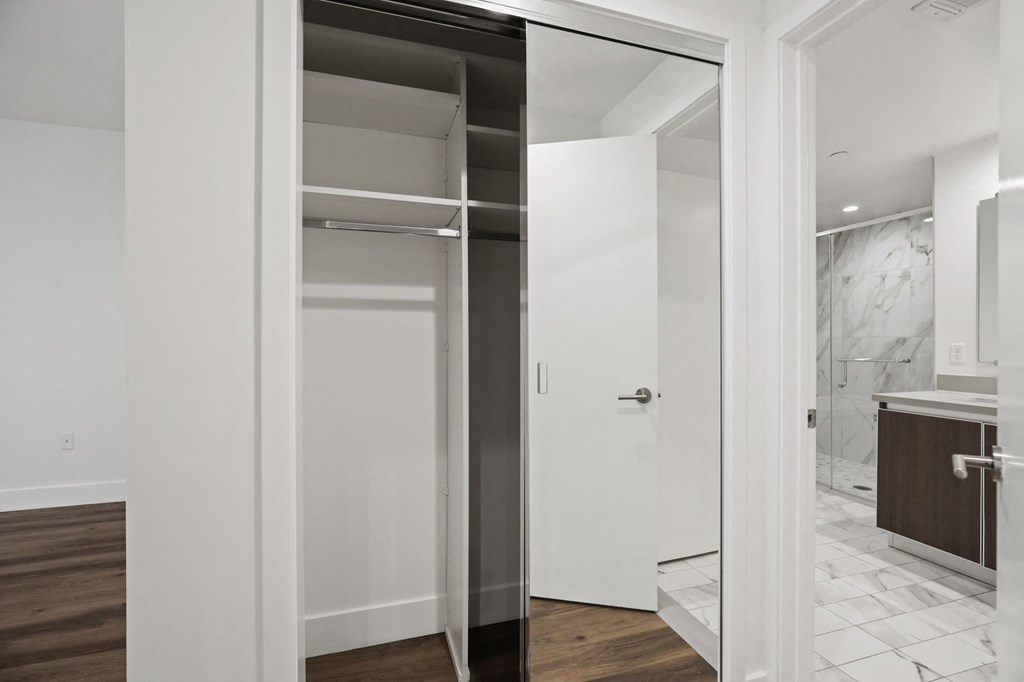 Bedroom with Mirrored Closet with Shelving, and Bathroom