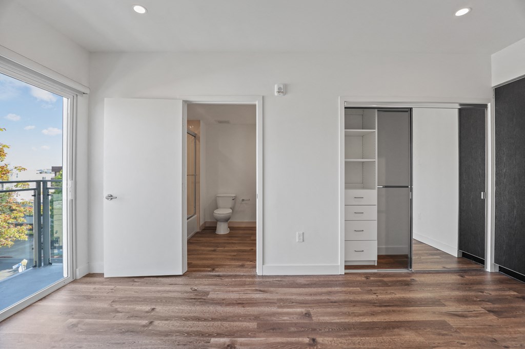 Large-Size Bedroom with Vinyl Flooring, Mirrored Closet, and Patio