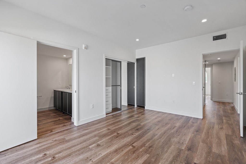 Spacious Bedroom with Closet with Organizers, Recessed Lighting, Vinyl Flooring, and Bathroom