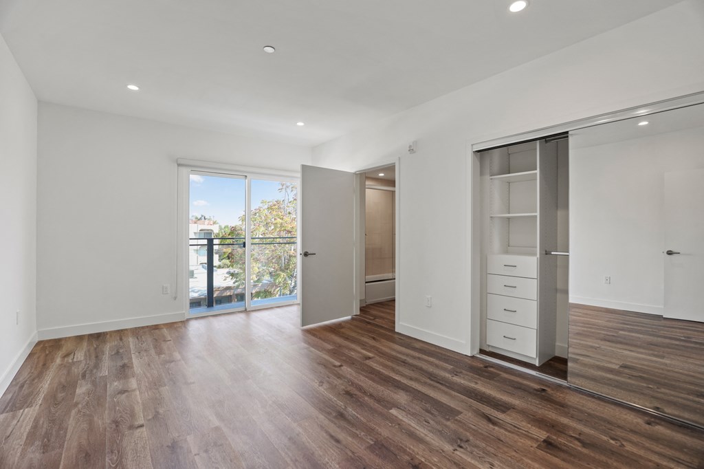 Bedroom with Vinyl Flooring, Large Closet with Built-In Organizers, Bathroom, and Patio