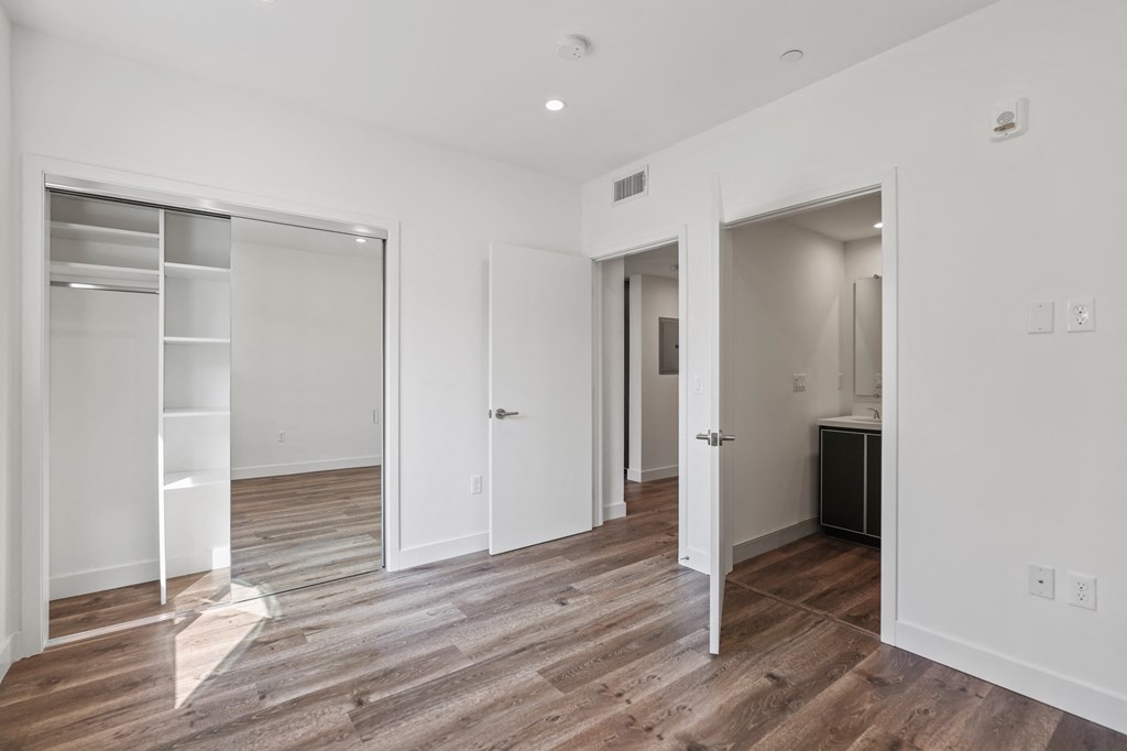 Bedroom with Mirrored Closet with Shelving, Vinyl Flooring, and Recessed Lighting