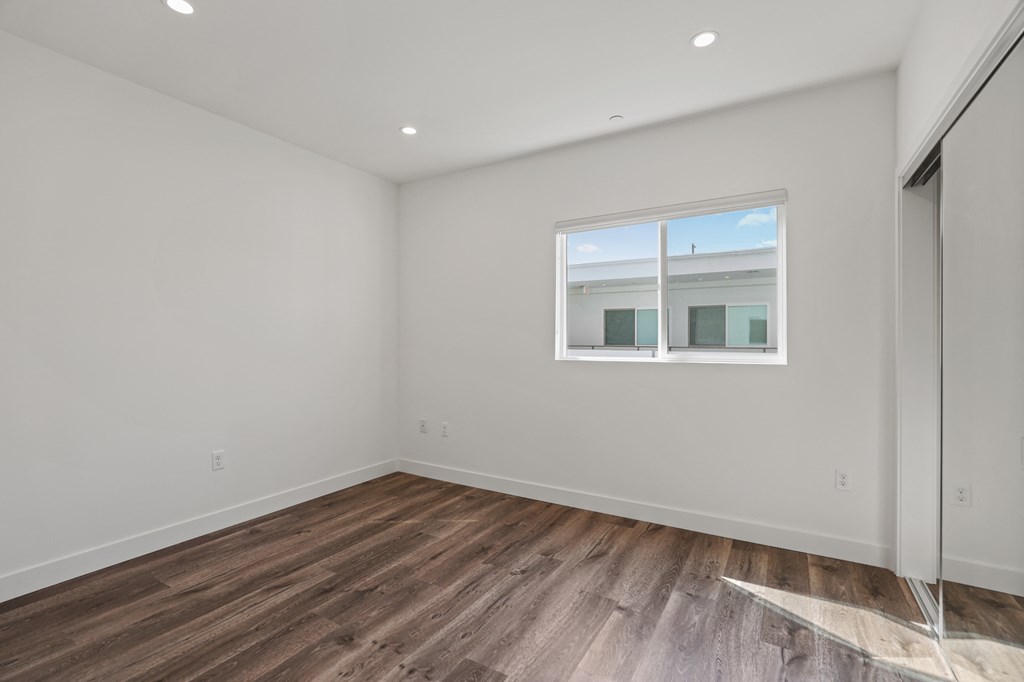 Bedroom with Recessed Lighting, Mirrored Closet, Vinyl Flooring, and Window