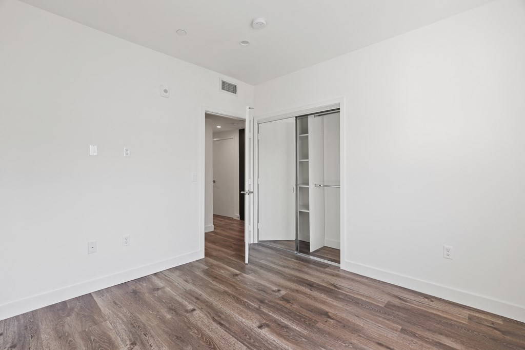 Bedroom with Mirrored Closet and Vinyl Flooring