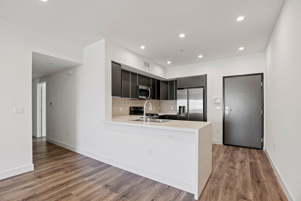 a kitchen with white countertops and black cabinets