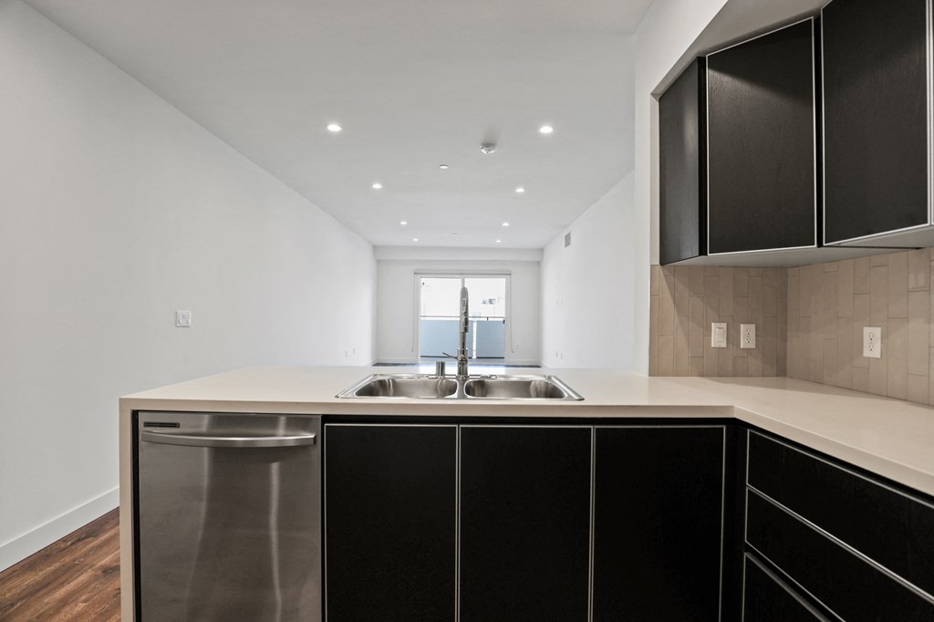 a kitchen with white countertops and black cabinets
