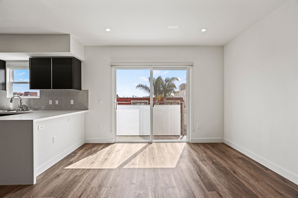 a kitchen with white cabinetry and hardwood floors