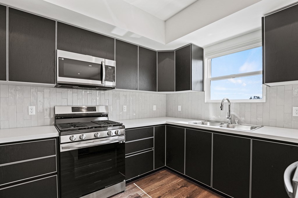 a kitchen with black cabinets and white countertops