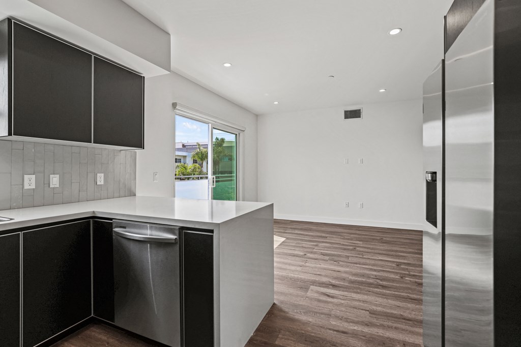 a kitchen with white walls and a wooden floor