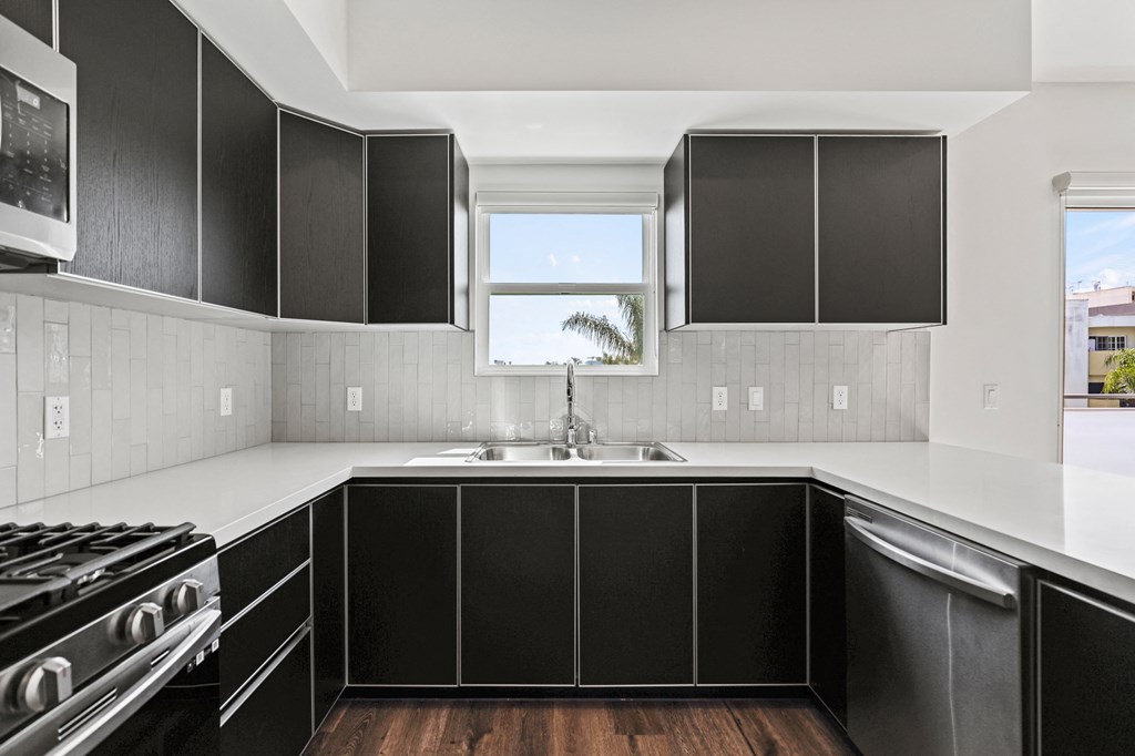 a kitchen with black cabinets and white countertops