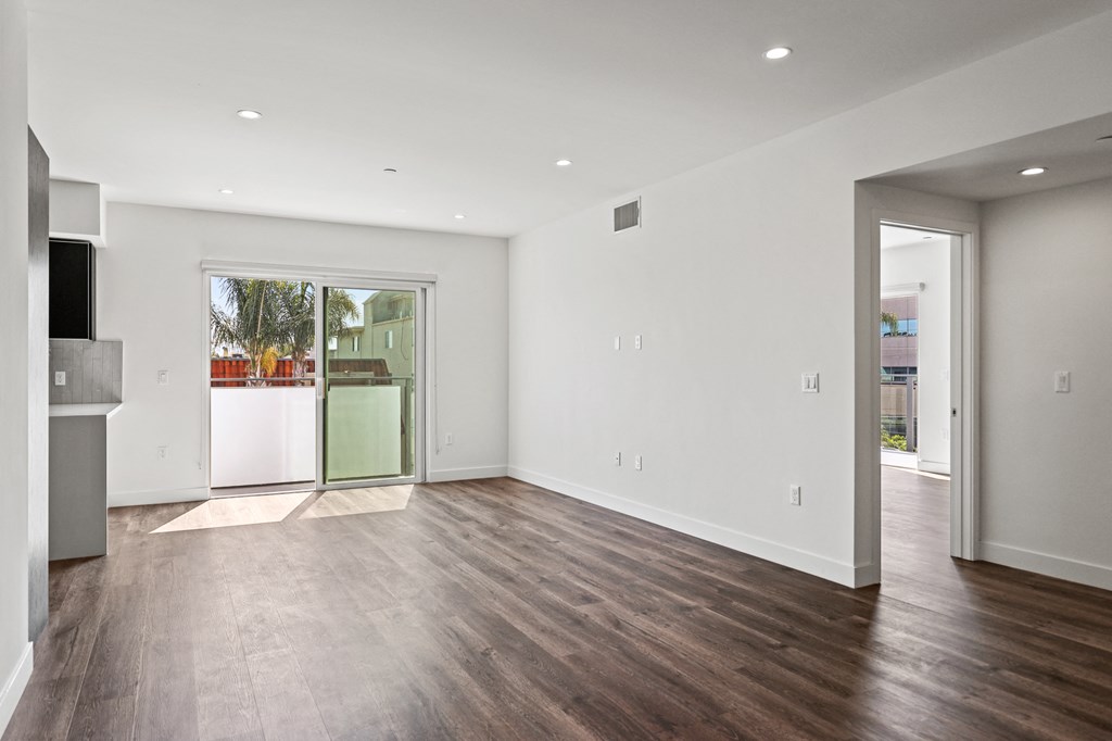 a bedroom with hardwood floors and white walls