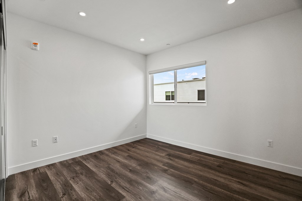 a bedroom with white walls and a window