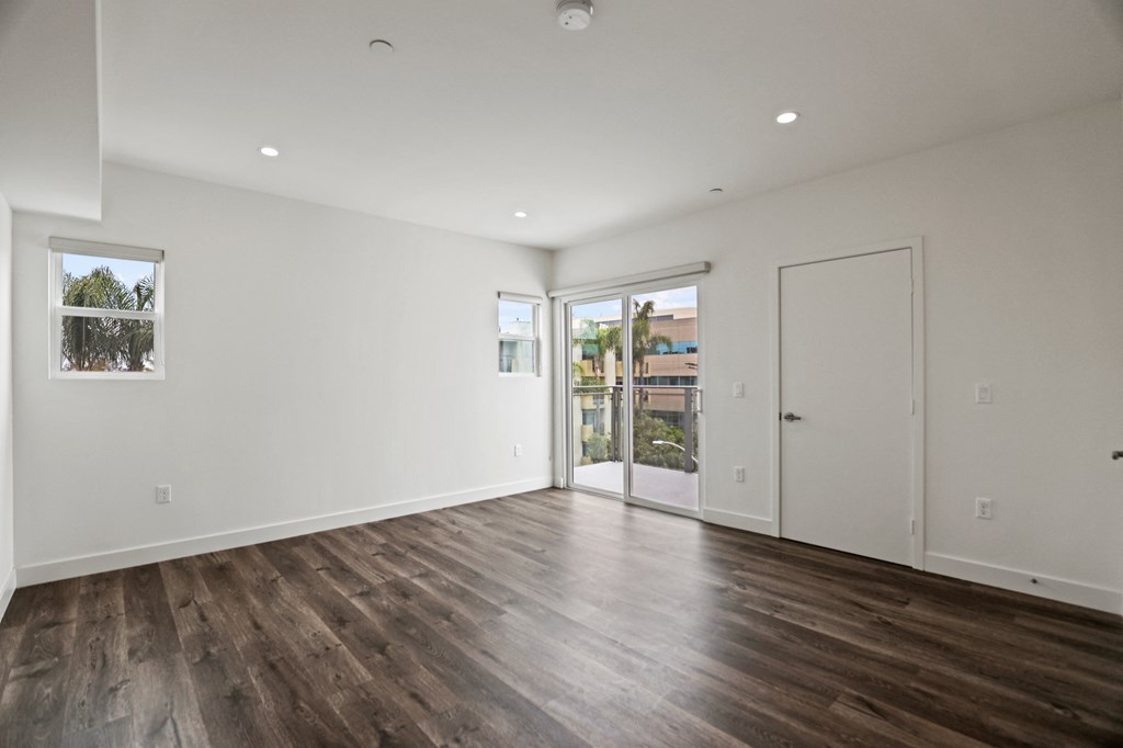 a bedroom with hardwood floors and white walls