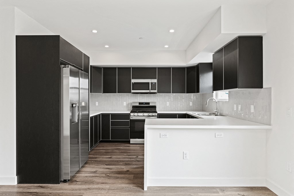 a kitchen with white countertops and black cabinets