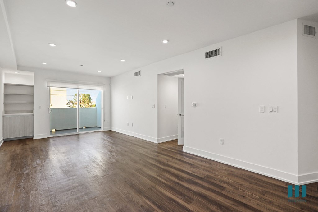 Spacious Living Room With Built-In Shelves, Vinyl Flooring, Recessed Lighting, and Patio