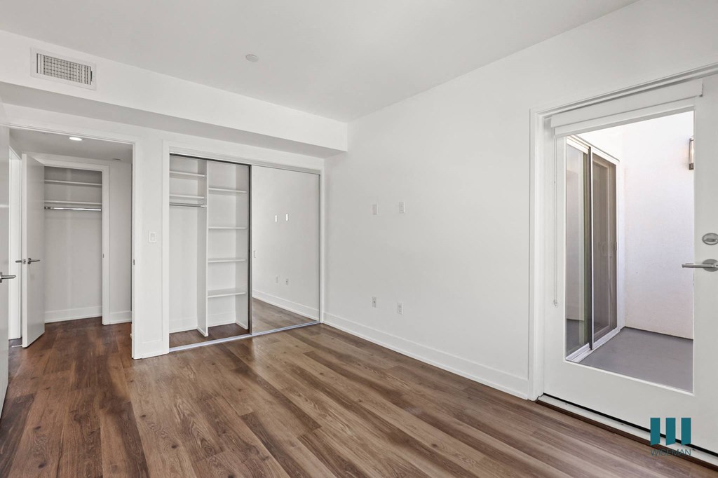 Bedroom with Mirrored Closet with Shelving, Vinyl Flooring, and Spacious Patio