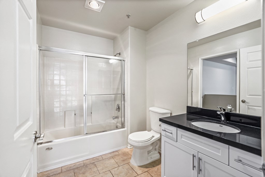Large-Size Bathroom with Bathtub with a Glass Door and Cabinet Storage
