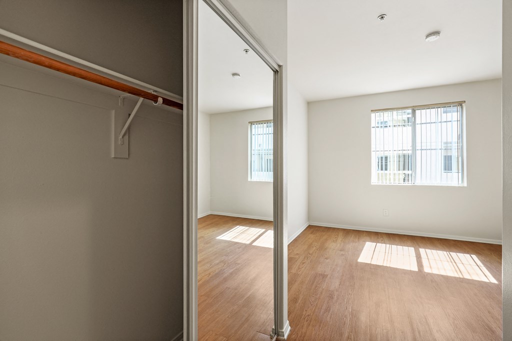 Bedroom with large Closet, Vinyl Flooring, and Large-Size Window