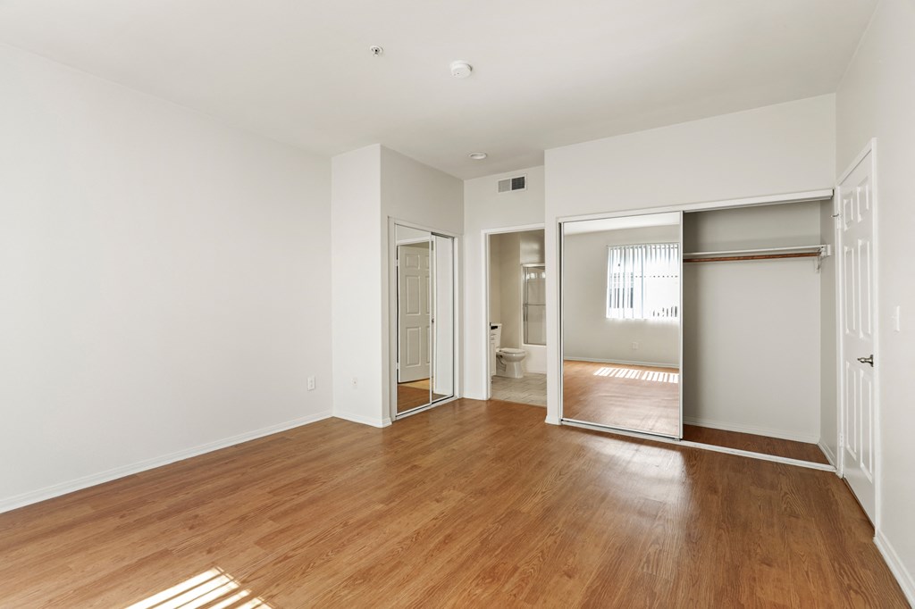 Bedroom with Two Mirrored Closets and Vinyl Flooring