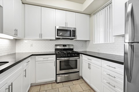 a kitchen with white cabinets and stainless steel appliances
