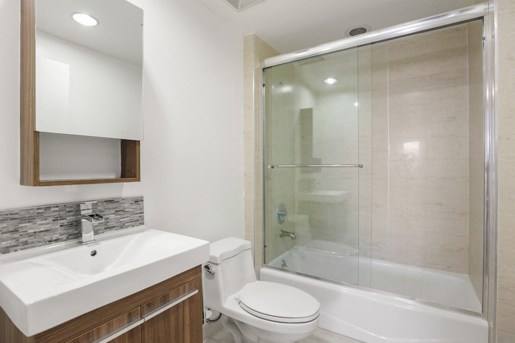 Bathroom With Full-Size Bathtub and Glass Door