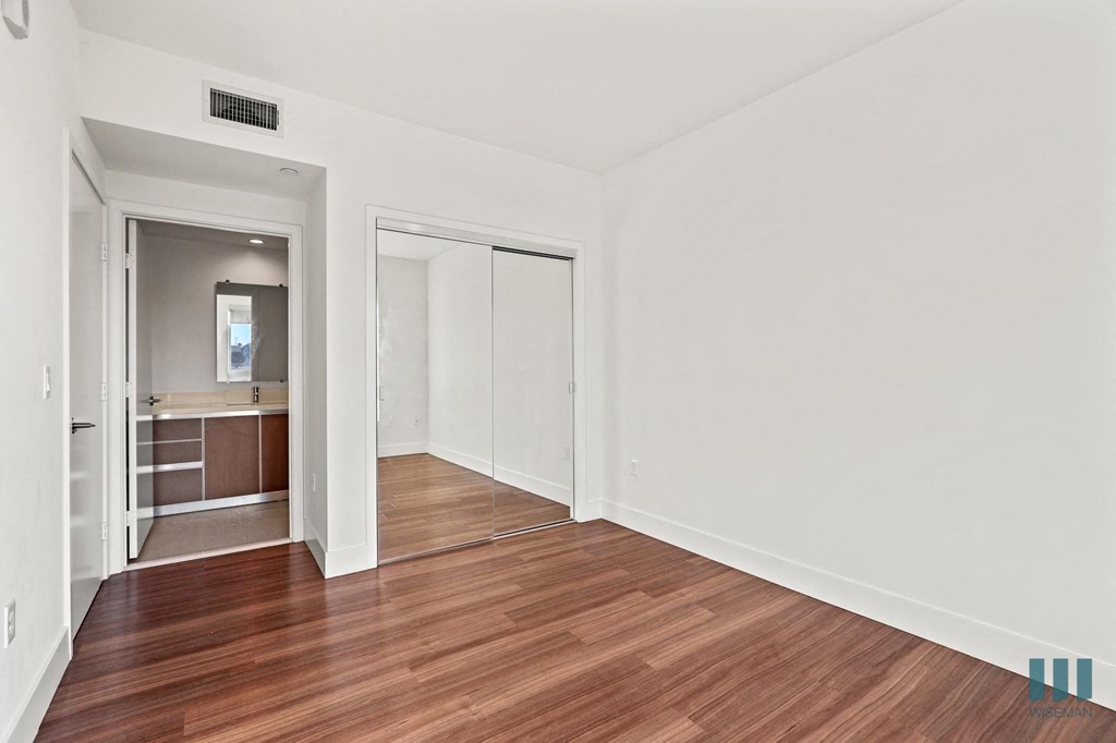 Bedroom with Bathroom, Mirrored Closet, and Vinyl Flooring