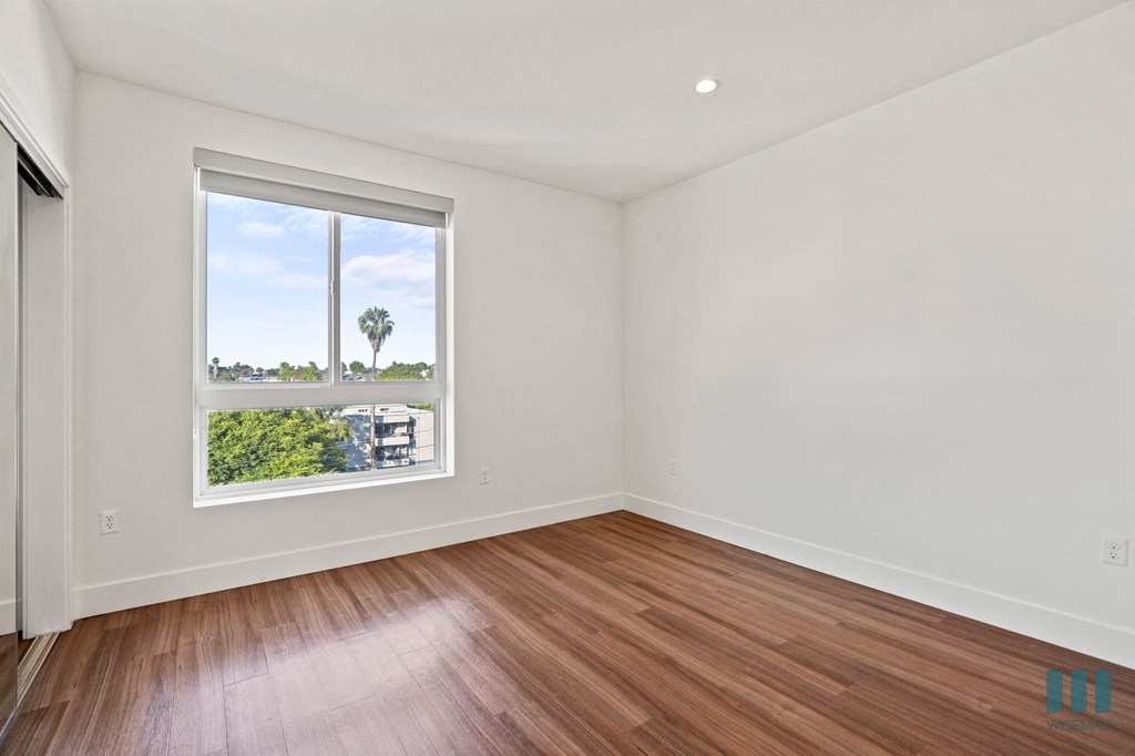 Bedroom with Large-Size Windows, Vinyl Flooring, and Mirrored Closet