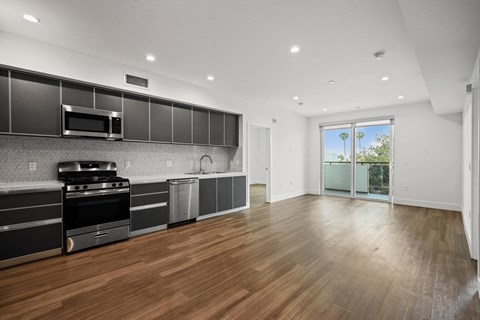 a kitchen with a stove and a microwave and a glass door