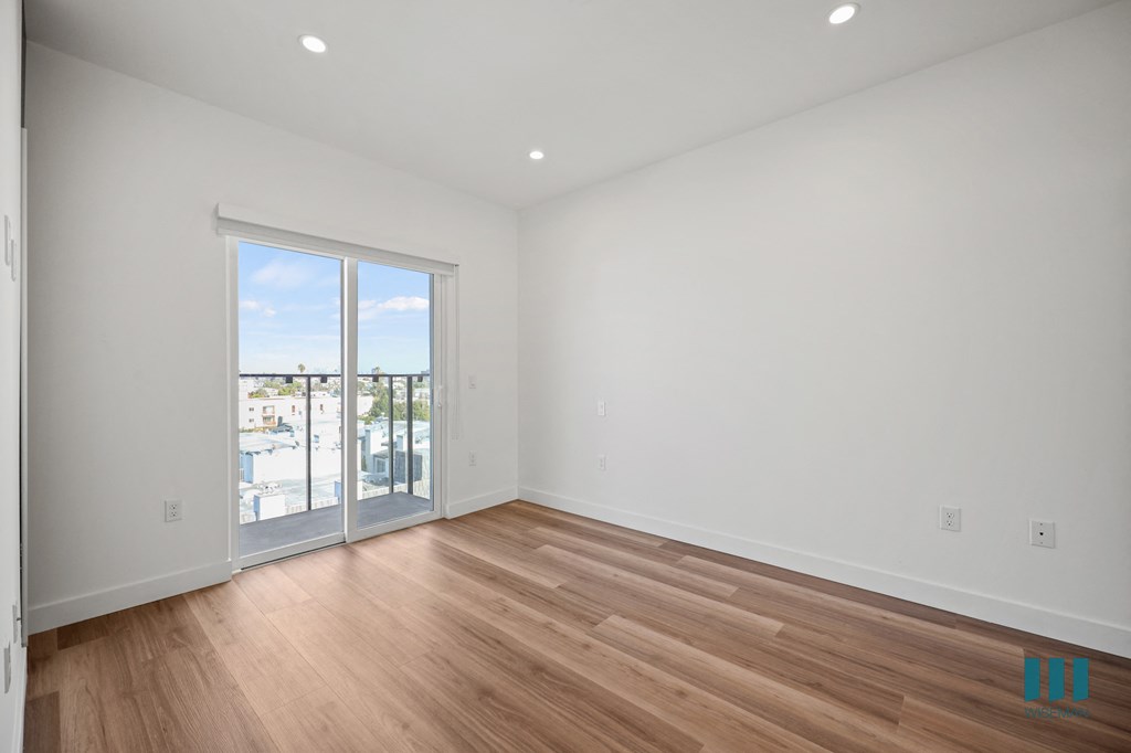 A room with a sliding glass door leading to a balcony.