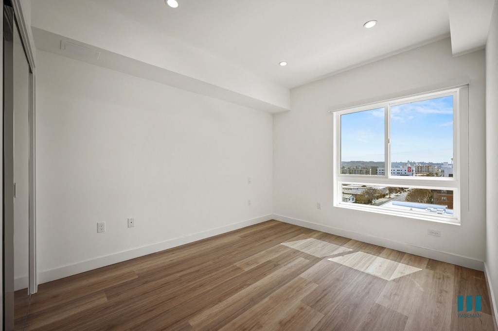A large empty room with a window overlooking a cityscape.