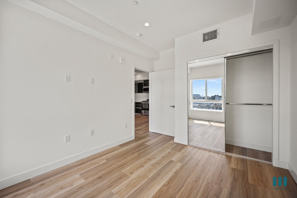 A room with a sliding glass door leading to a balcony.