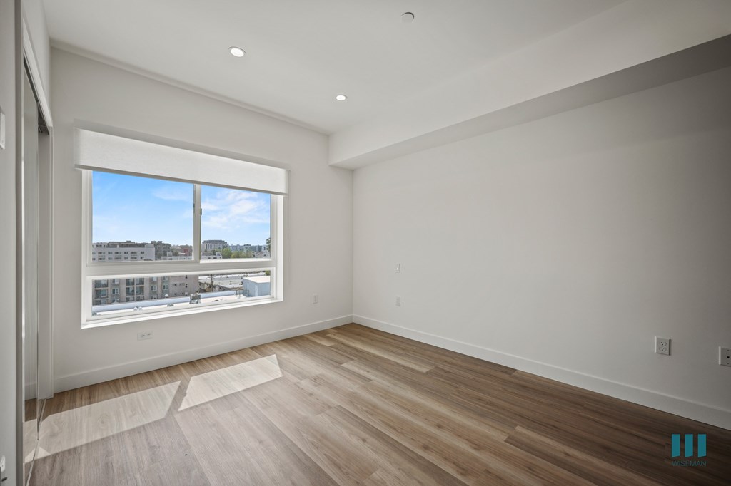 A room with a large window and wooden flooring.