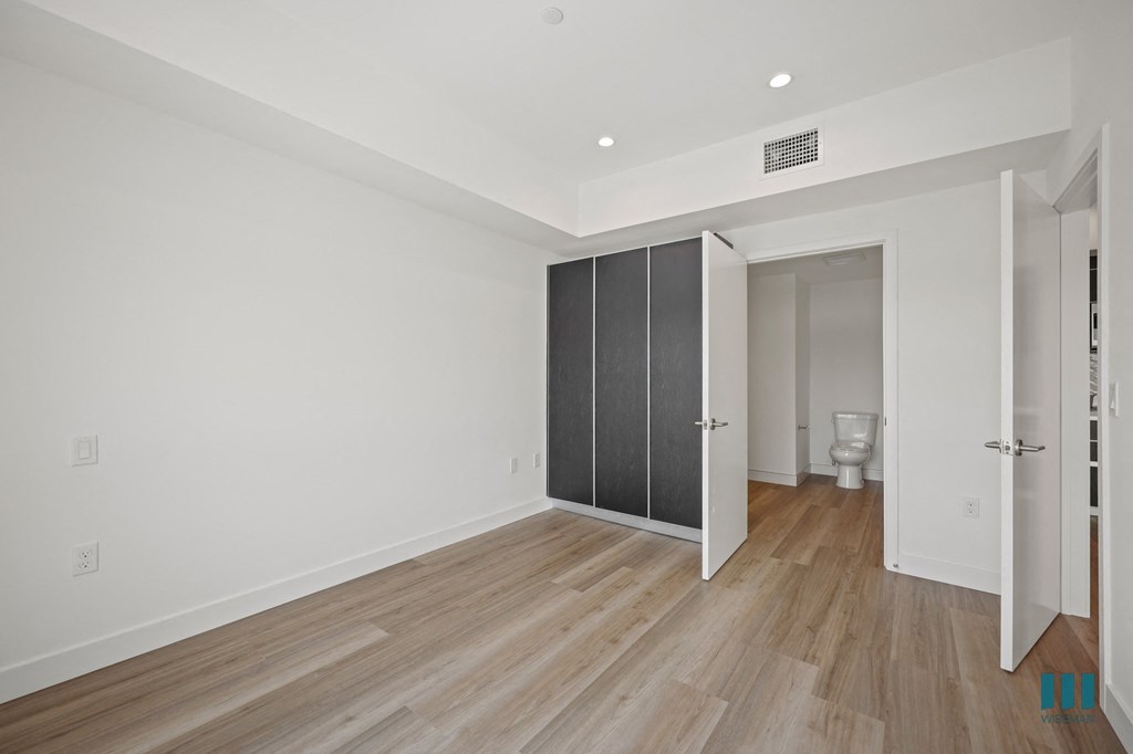 A room with a toilet and a cabinet.