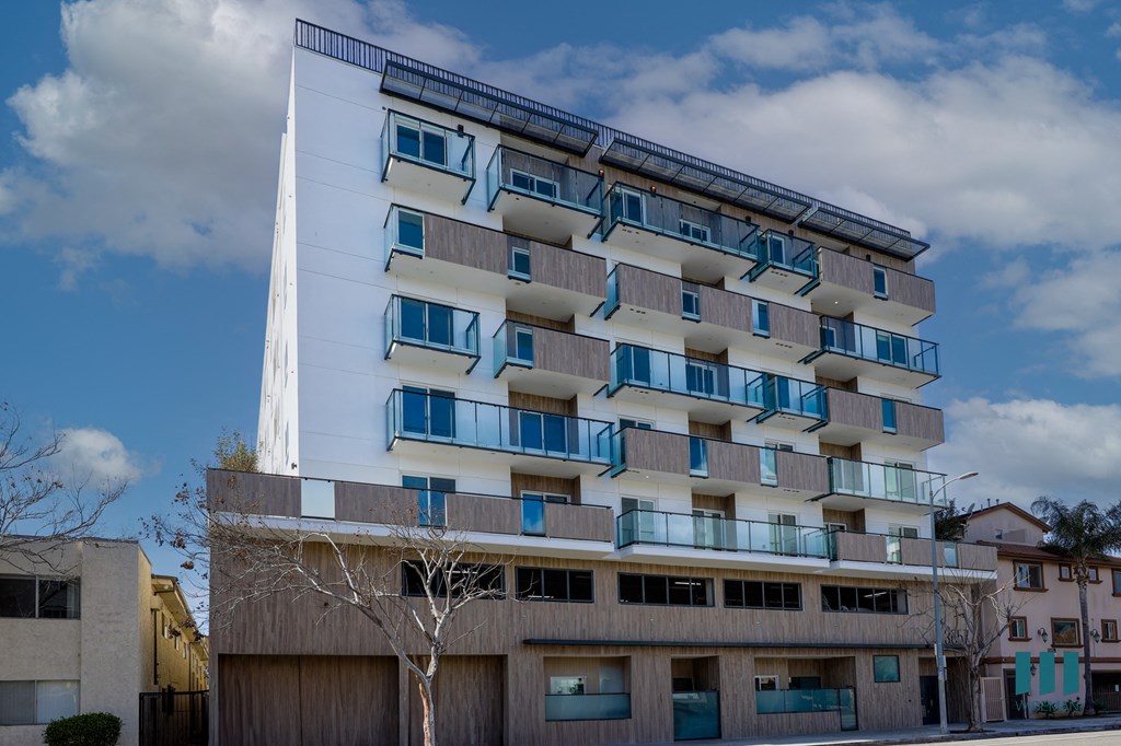 A modern building with a white facade and blue balconies.