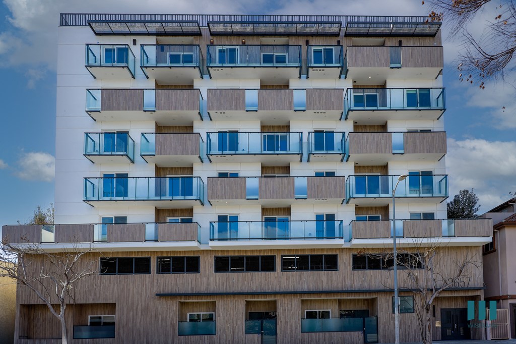 A modern building with balconies and a flat roof.
