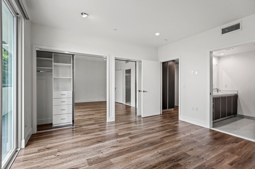 Bedroom with Two Closets with Built-In Organizers, Balcony, and Bathroom