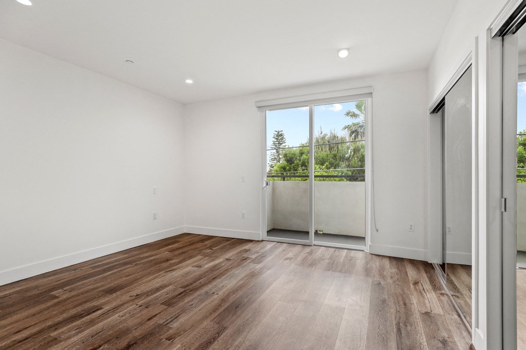 Bedroom with Recessed Lighting, Vinyl Flooring, and Two Mirrored Closets