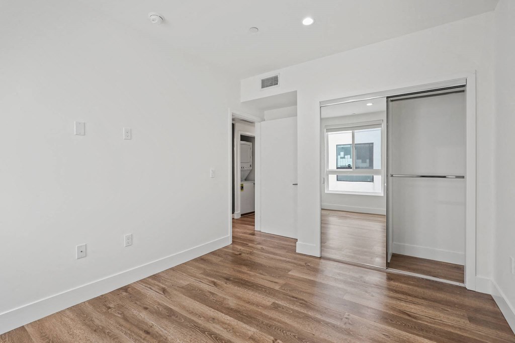 Bedroom with Mirrored Closet, Recessed Lighting, and Vinyl Flooring